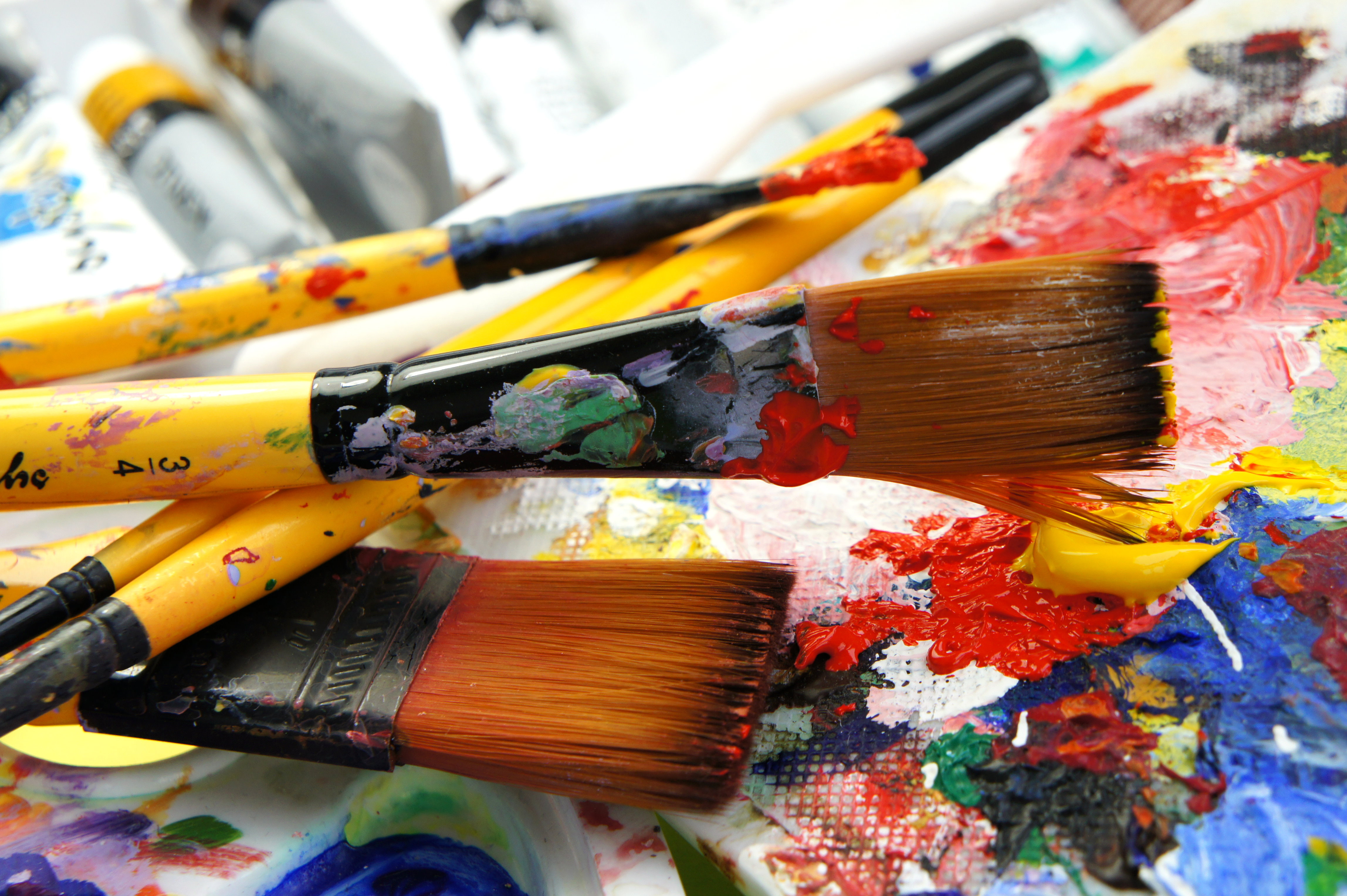 An artist palette with brushes filled with various paints Birmingham